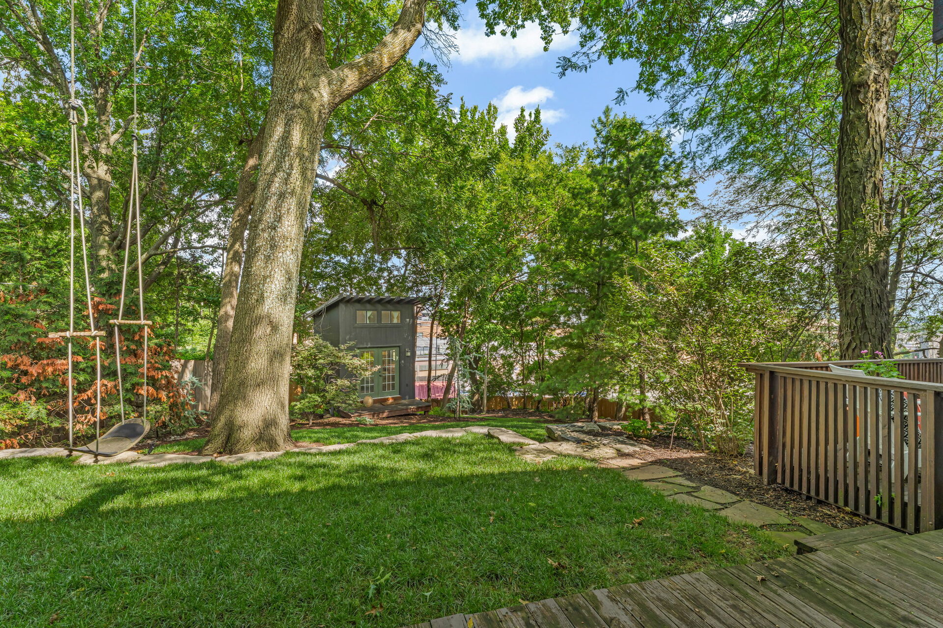 Backyard with mature trees and detached studio in the background