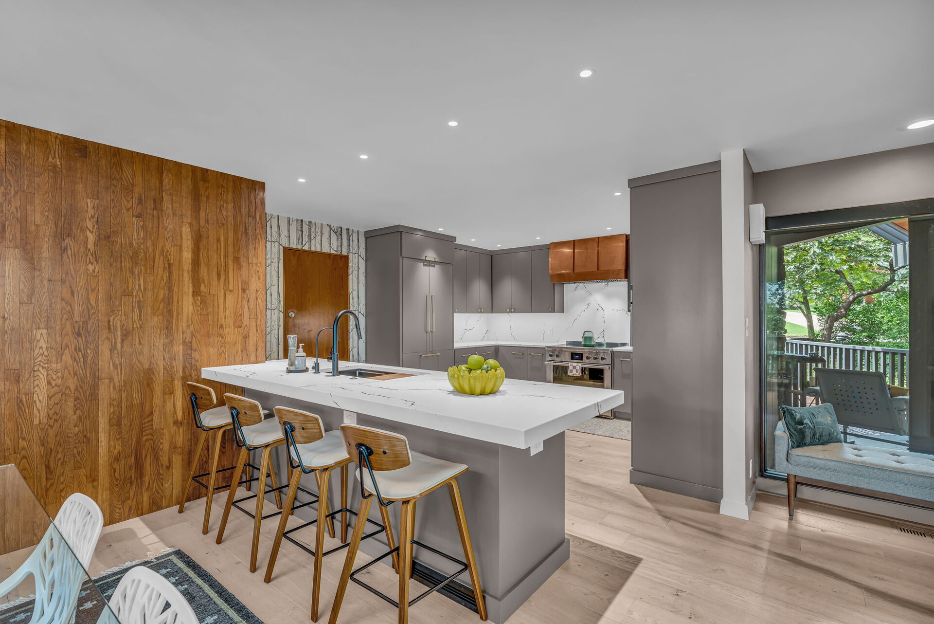 Kitchen island with waterfall countertop and wood accent wall