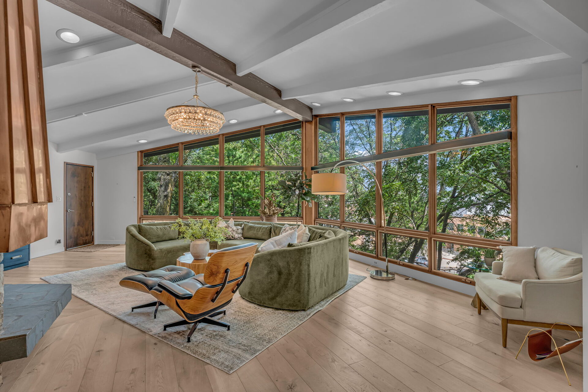 Living room floor-to-ceiling window wall with tree views
