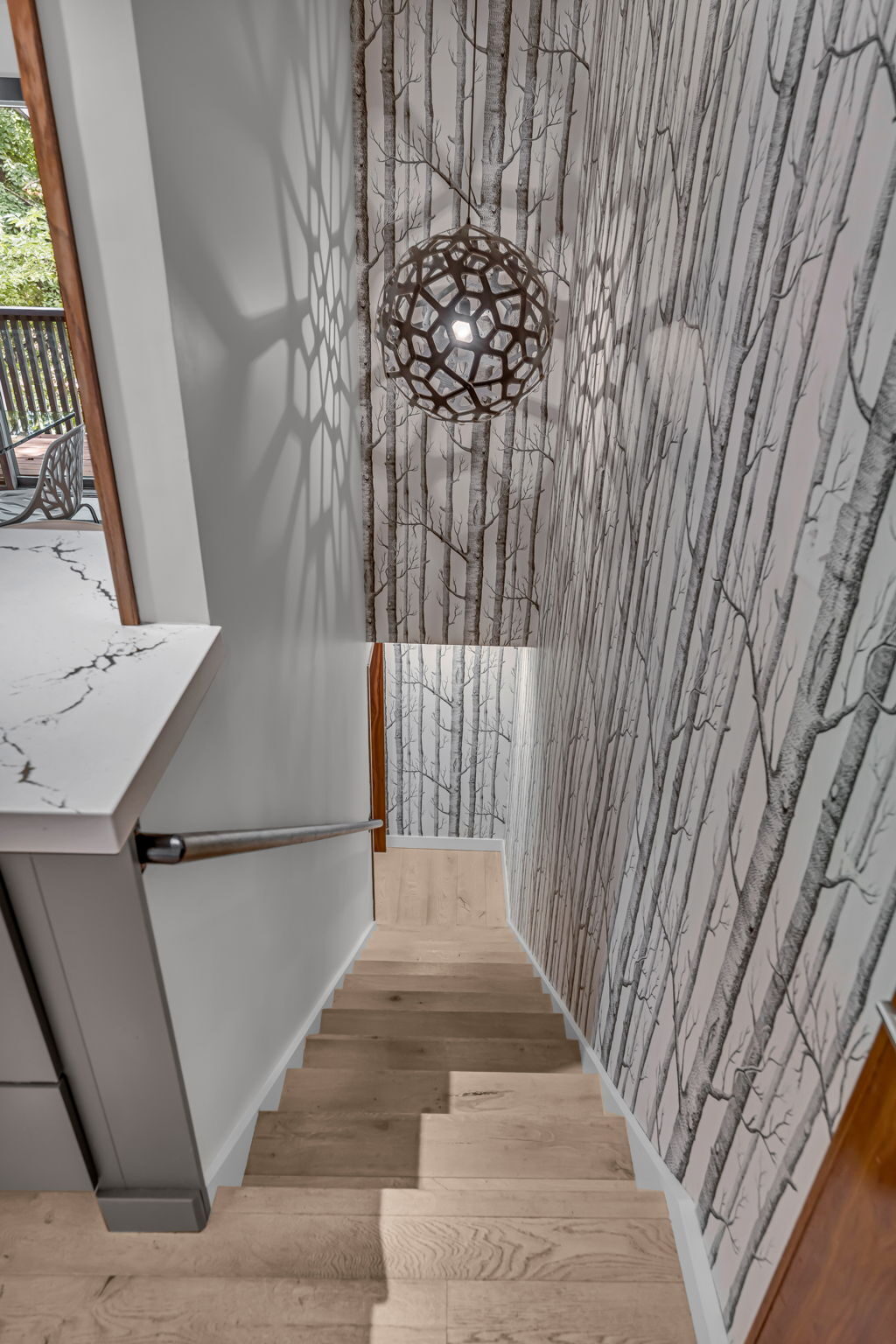 Stairwell with birch tree wallpaper leading to lower level
