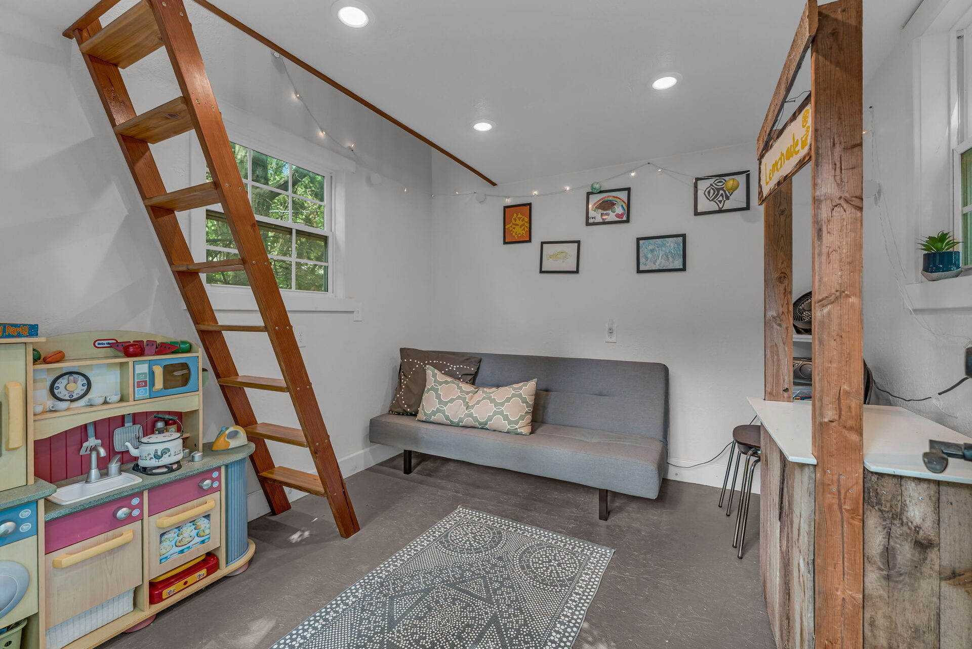Interior of the backyard studio, currently set up as a kids' playhouse with a loft
